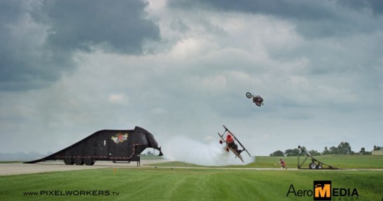 Motocykl przeskakuje nad lecącym samolotem