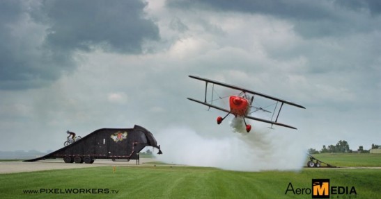 Motocykl przeskakuje nad lecącym samolotem