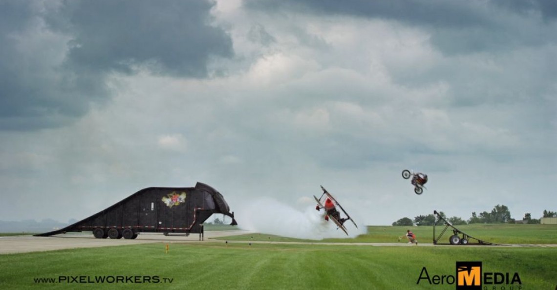 Motocykl przeskakuje nad lecącym samolotem