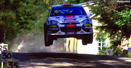 Szybujcy Colin McRae, a w tle synnek domek